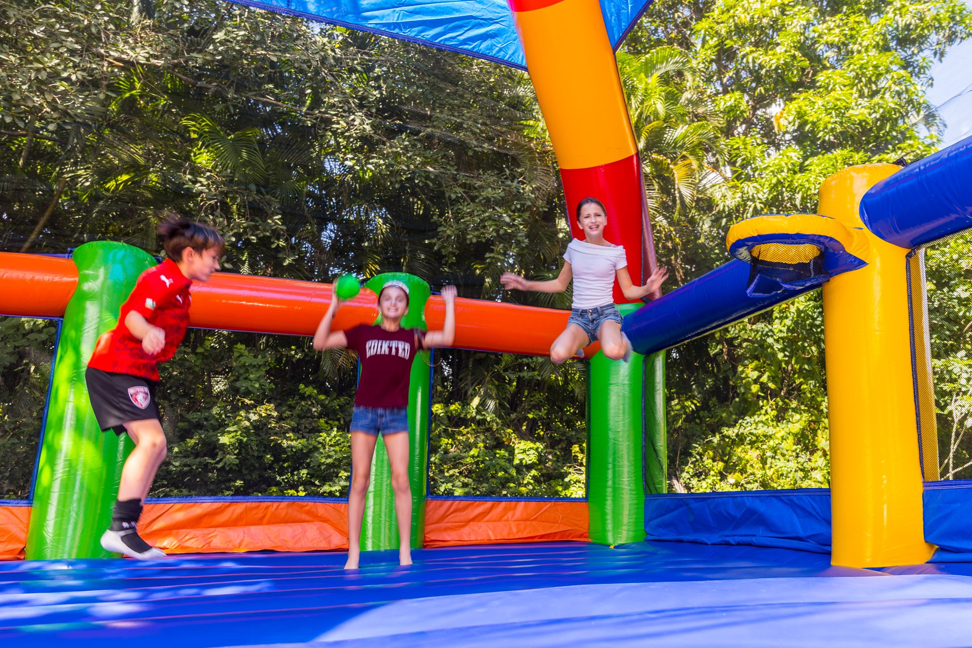 Children caught in mid-jump on the inflatable trampoline